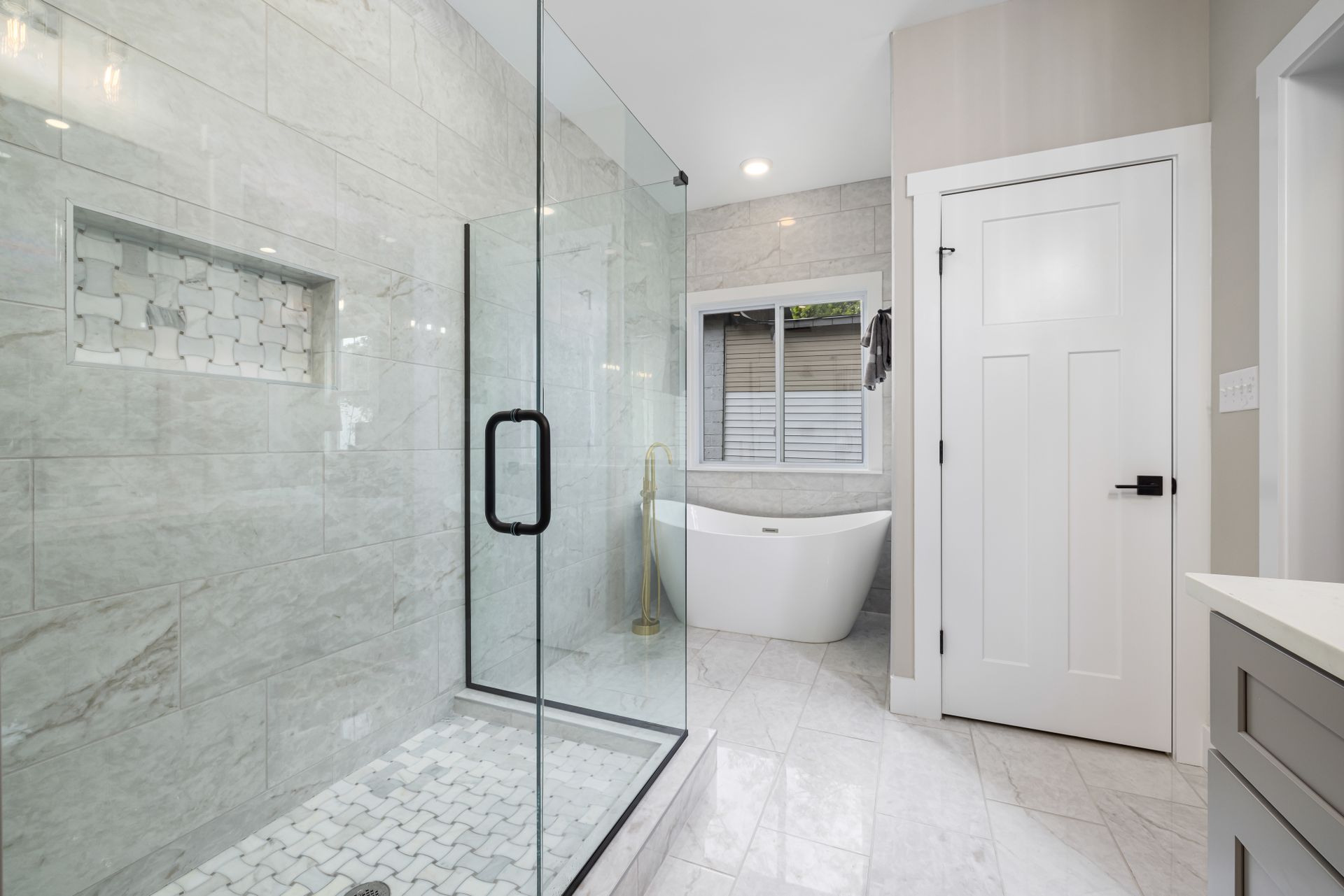 A bright, newly renovated bathroom with a walk-in shower and freestanding bath
